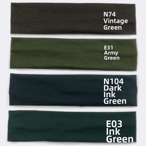 Detailed stack of cotton sports headbands in four shades of green with fabric texture