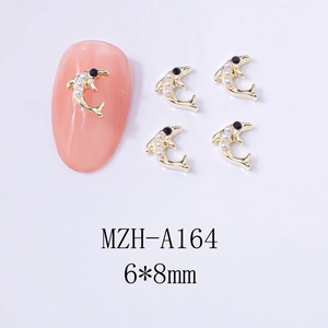 Detail of dolphin nail charms with gold alloy base, white pearls and black rhinestones