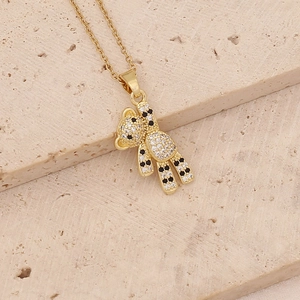 Close-up of a gold bear pendant with sparkling white and black cubic zirconia stones