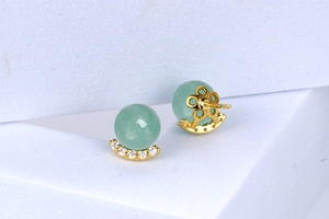 Macro detail of gold-plated green aventurine stud earrings with sparkling zircon accents