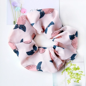 Pink fabric hair scrunchie with cute strawberry patterns and soft texture detail
