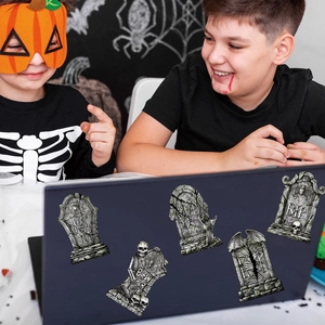 Kids with Halloween tombstone stickers featuring skulls and bats on a laptop
