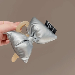 Silver metallic puffed bow hair claw clip with Y2K style for ponytail styling