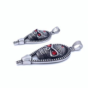 Detail of vintage skull pendant with red stone eyes and zipper design in silver steel