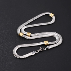 Flat silver mesh chain necklace with golden beads and lobster clasp on black background