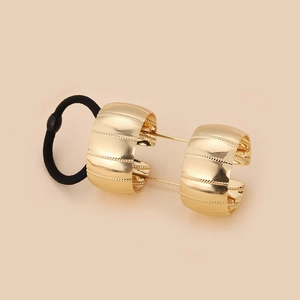 Minimalist gold metal hair tie ring with textured finish on a black elastic band