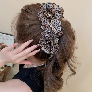 Detail view of the layered leopard print fabric flower hair clip on a ponytail hairstyle