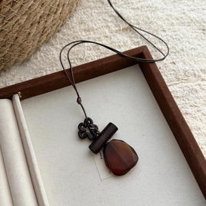 Close-up of vintage wood resin pendant necklace with floral and geometric elements