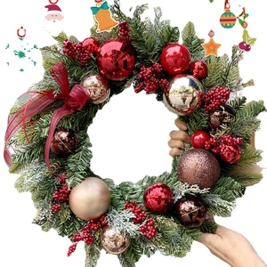 Christmas wreath with green needles, red berries, gold ornaments and a red ribbon bow