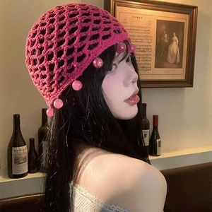 Pink bohemian crochet beanie featuring hollow knit pattern and decorative hanging beads