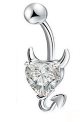 Macro shot of silver devil heart navel ring featuring clear zircon stone and demon tail