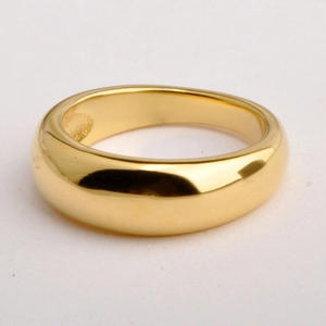 Minimalist smooth gold plated metal ring with thick rounded surface on white background