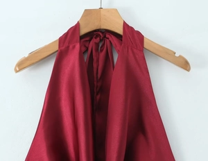Detalle de un top de satén rojo con cuello drapeado y textura sedosa con brillo fino