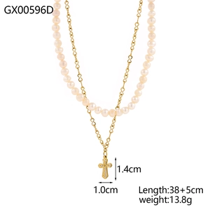 Detailed view of layered necklace with natural pearls and a crystal cross pendant