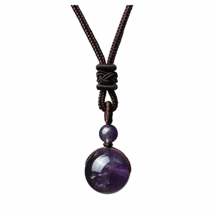 Détail d'un pendentif rond en améthyste avec cordon en corde tressée marron et nœud