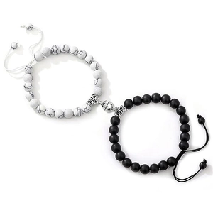 Detail of couple magnetic heart bracelets with white stone and black matte beads