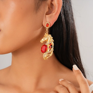Detail of horse head earring with a red oval gemstone and diamonds on a model