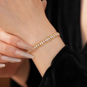 Close-up of elegant double-row gold chain bracelet with sparkling white cubic zirconia stones