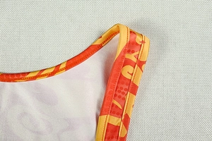 Dettaglio dello scollo e della spallina di un abito attillato con stampa geometrica