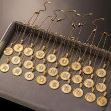 Detailansicht goldener Titanhalsketten mit Zirkon-Donut-Anhängern in einer Schmuckschale