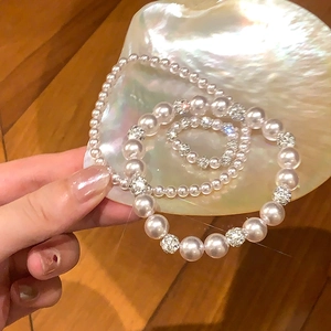 Vue détaillée du bracelet et de la bague en perles dans un support en coquillage