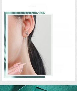 Detail of S925 silver snake earrings with green eyes and dangling fringe chains