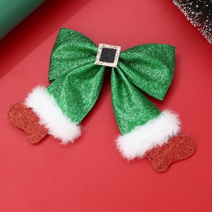 Macro detail of Christmas glitter hair clip with green bow and red glitter stocking charm
