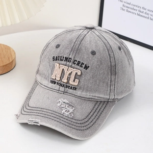 Detail of vintage gray washed denim baseball cap with NYC embroidery and distressed finish