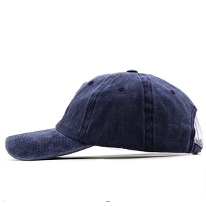 Side view of washed cotton baseball cap in navy blue with breathable eyelets and stitching