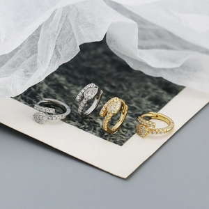 Detail of silver and gold zircon hoop earrings on vintage paper with luxury textures