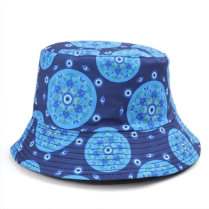Dettaglio del cappello a secchiello con motivi mandala blu e simboli dell'occhio greco