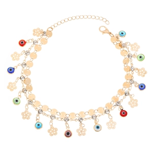 Detailed close-up of golden anklet featuring colorful evil eye beads and floral pendants