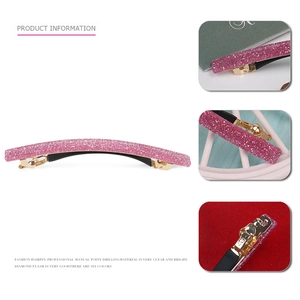Close-up of pink glitter acrylic hair clip with golden metal base and spring closure