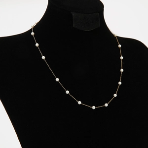 Elegant French baroque gold necklace featuring white pearls on a black display bust