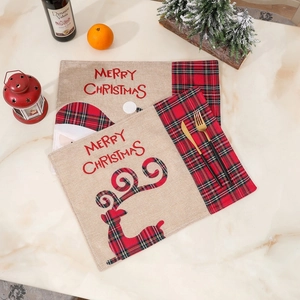 Close-up of linen Christmas placemats with Santa and reindeer motifs on marble table