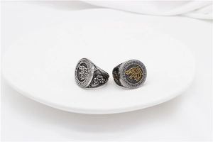 Macro view of two vintage Viking rings featuring wolf head reliefs and Rune engravings