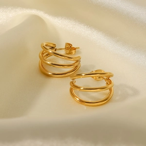 Macro shot of 18K gold plated triple layered geometric hoop earrings on silk