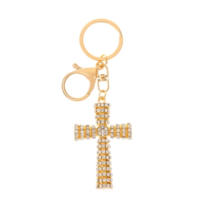 Close-up of golden cross keychain with sparkling rhinestones on a white background