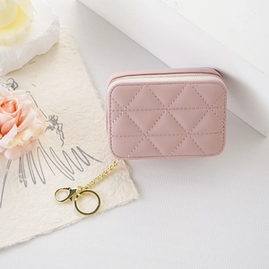 Pink quilted PU leather mini cosmetic pouch with mirror and gold keychain on white desk