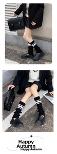 Detail of black knitted leg warmers with white stripes in academic Y2K style fashion
