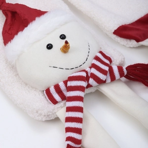 Close-up of plush snowman face with knitted red and white striped Christmas scarf detail