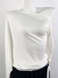 Detailed view of the white ribbed knit sweater showing the asymmetric cold shoulder neckline
