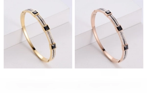 Detail of gold and rose gold bangles with square black stones and white rhinestones