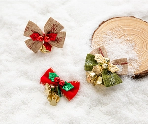 Close-up of Christmas bows with bells, holly leaves, and Merry Christmas print