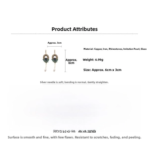 Détail de boucles d'oreilles vintage dorées avec strass sarcelle et perles de goutte