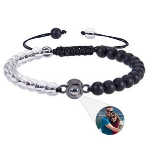 Macro shot of custom photo projection bead on adjustable black and white beaded bracelet