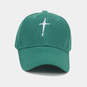 Detailed view of white star embroidery on dark green cotton twill baseball cap