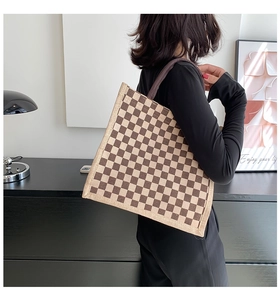 Detail of checkered linen tote bag showing vintage canvas texture and fabric handle