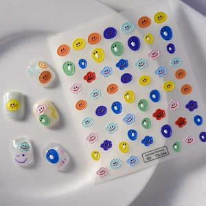 Detail showing 5D embossed nail stickers with colorful cartoon smiles and clouds texture