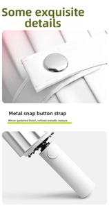 Detail of white umbrella featuring a metallic snap button strap and auto-open handle